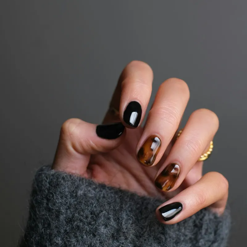 Almond-shape gel manicure in cream against a warm background