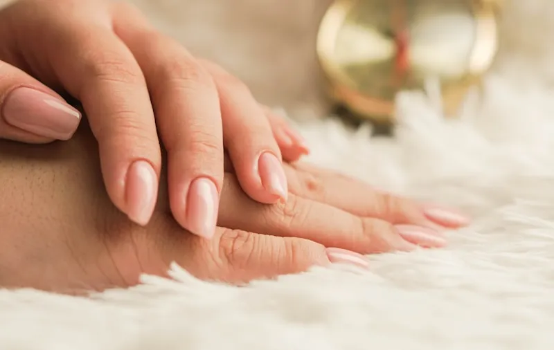 Pedicure with red polish, foot resting on a warm towel